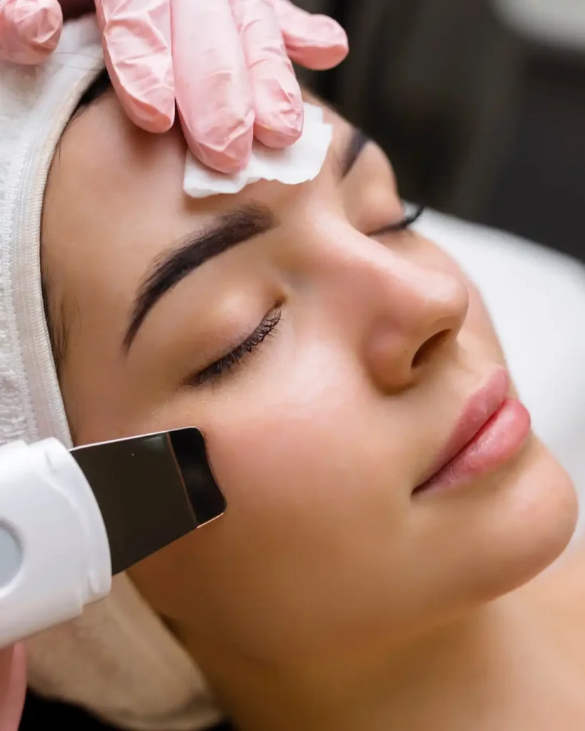 Close-up of a woman receiving professional facial treatment with a skincare device for deep cleansing, exfoliation, and glowing skin results.